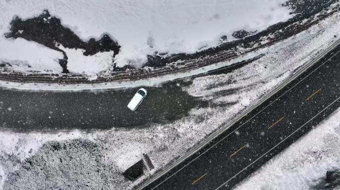 俯拍一辆白色汽车停在雪地上