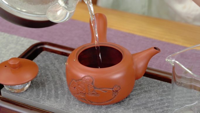 慢动作将热水倒入茶壶中冲泡茶叶