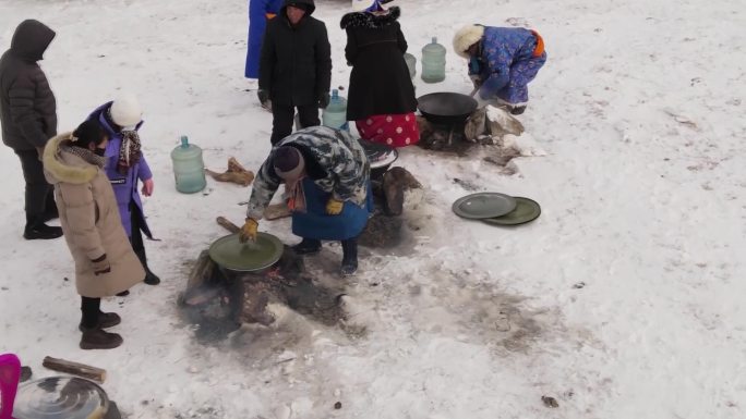 冬季草原牧民在雪地上架锅煮肉手把肉兴畜节