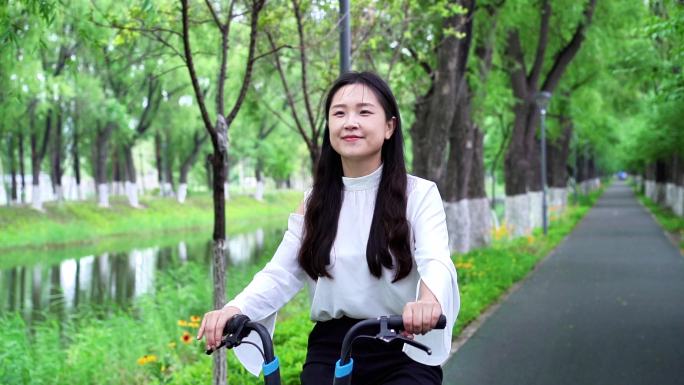 春天自然唯美城市女子骑自行车健康低碳生活