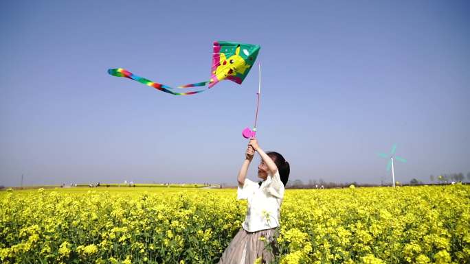 小女孩在油菜花田中放风筝