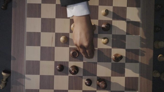 男人手拿国际象棋棋盘下棋