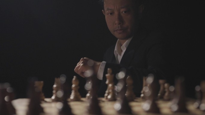 男人坐在国际象棋棋盘前思考