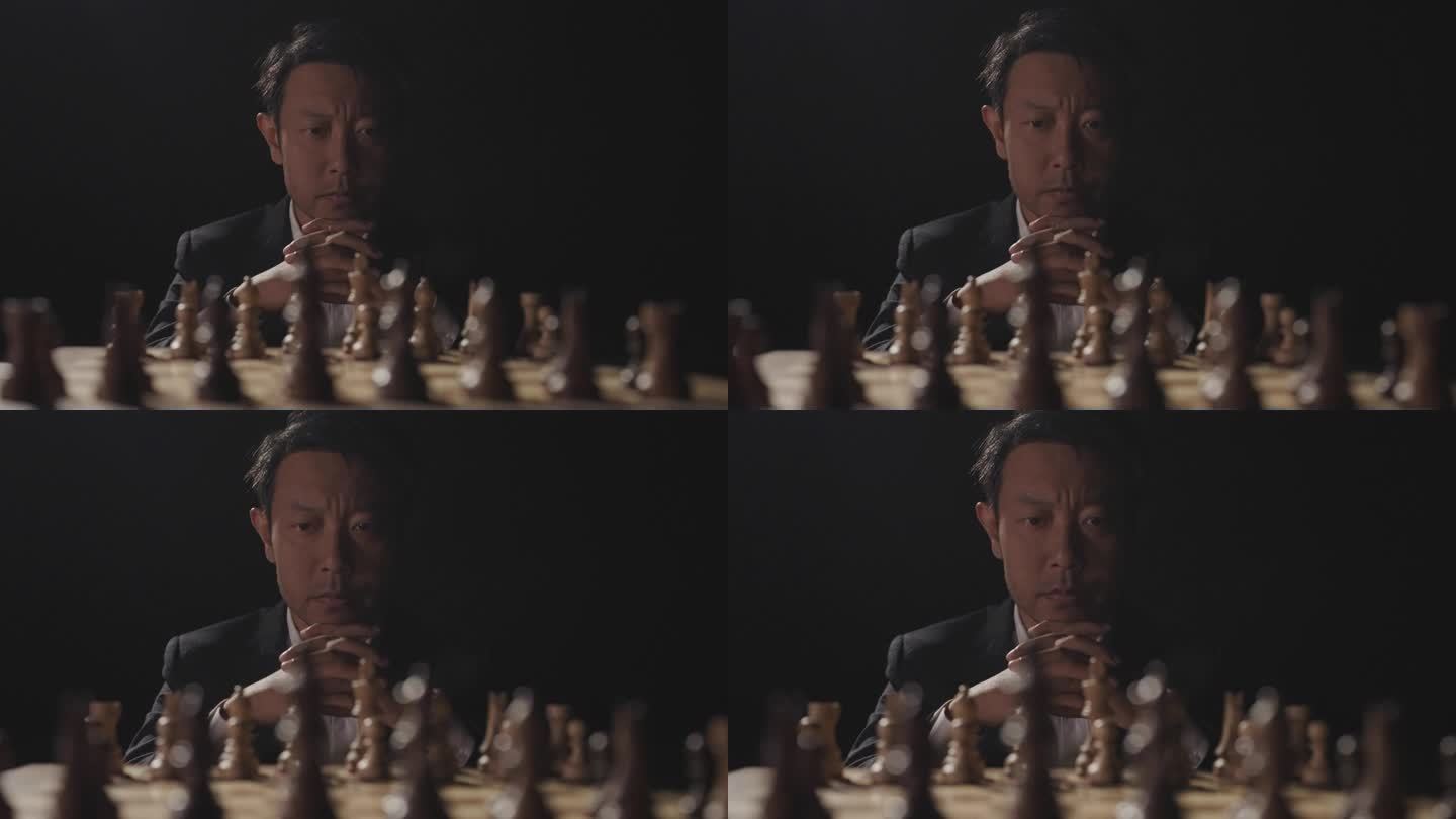 男人坐在国际象棋棋盘前观察思考