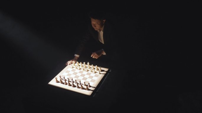 男人黑暗中下国际象棋思考对局对弈