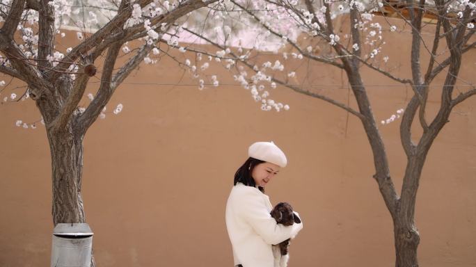 年轻女子抱着小羊羔新疆杏花村旅行