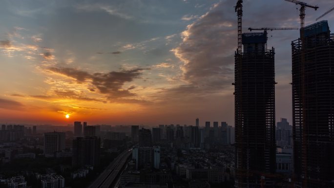 城市建筑工地塔吊城市日出朝霞城市夜转日