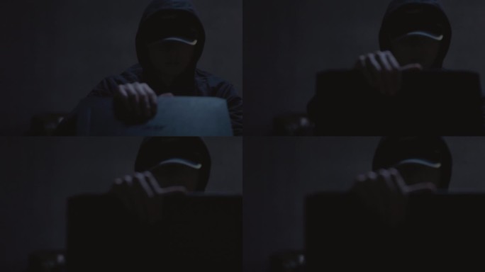 黑暗中男人黑客打开电脑