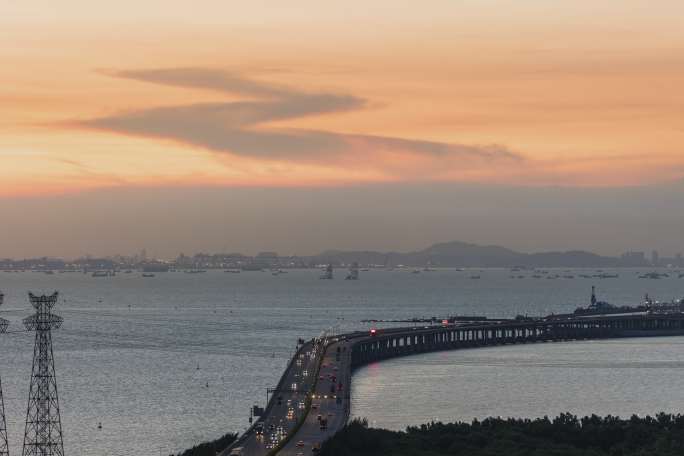 广深沿江高速公路傍晚车流与海上高压电塔