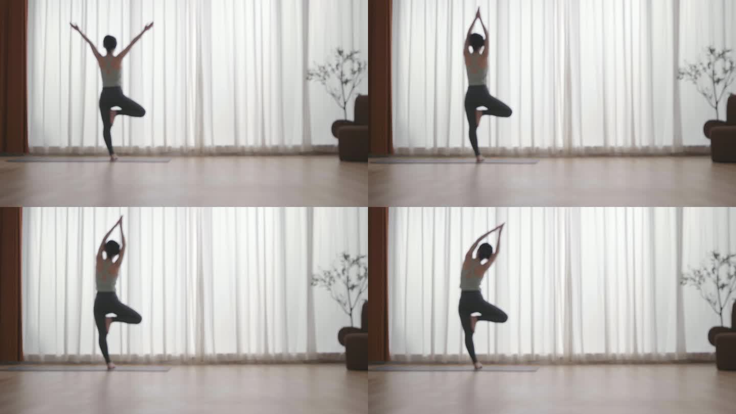 女人在客厅室内做瑜伽单脚站立伸展