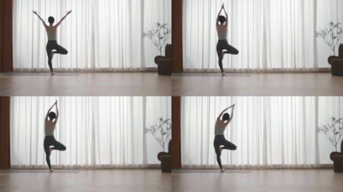 女人在客厅室内做瑜伽单脚站立伸展