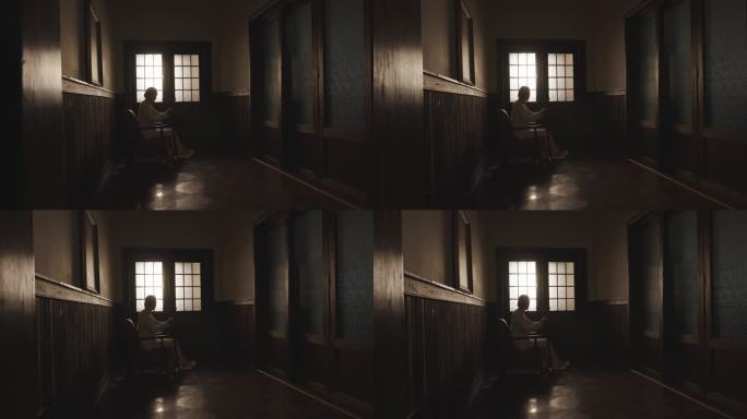 老年女人独自坐在走廊看门外