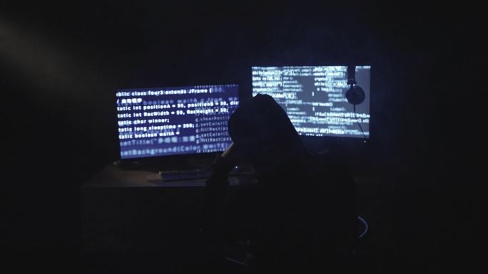男人黑客破译黑暗房间程序乱码电脑屏幕背影
