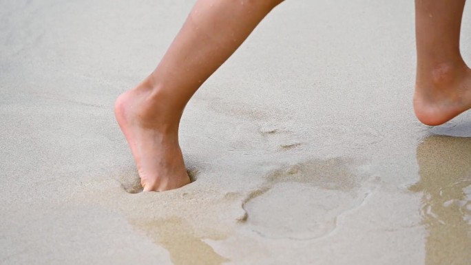 海边沙滩上海浪浪花与儿童脚丫