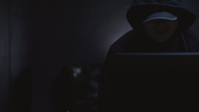 黑暗中男人黑客使用电脑