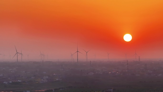 航拍夕阳落日太阳风力发电站群村庄农户平原