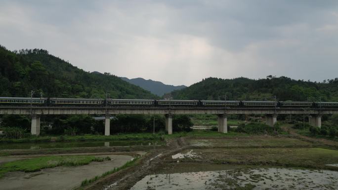 绿皮火车驶过乡村桥梁