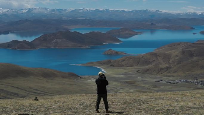 4k男人在航拍西藏蓝色羊湖雪山