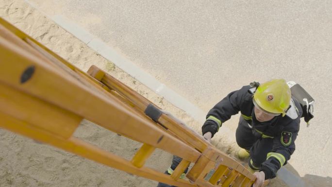 消防员双人合作进行高空救援爬梯训练