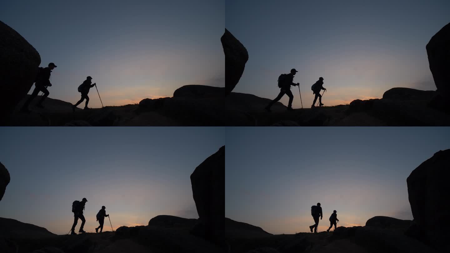 两个人走在山脊上的剪影
