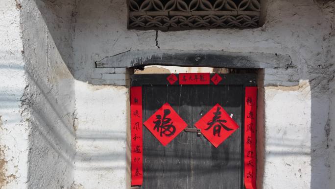 华北地区的传统手写春联贴在老门上