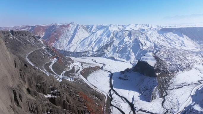 航拍新疆冬季安集海大峡谷红色山脉雪山河流