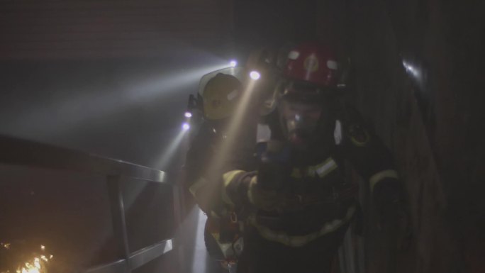 消防队员扑灭火焰进入火灾室内爬楼梯