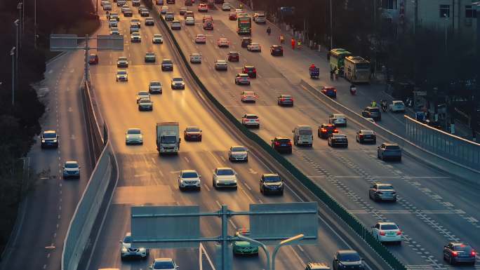 城市夕阳下繁忙道路上行驶的汽车