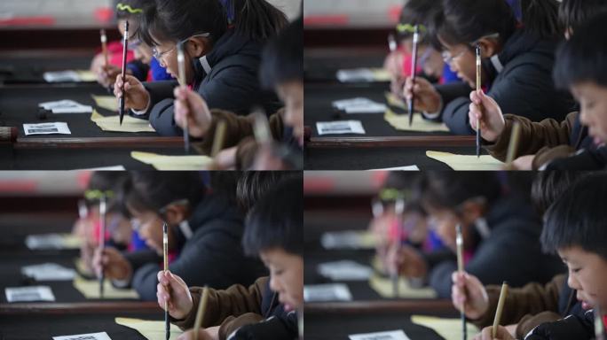 学校小学生手拿毛笔写毛笔字书法课实拍素材