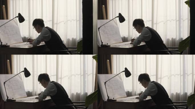 男人趴在桌上工作画图设计稿图纸