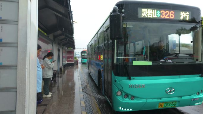 下雨天马路上公交车进站出站