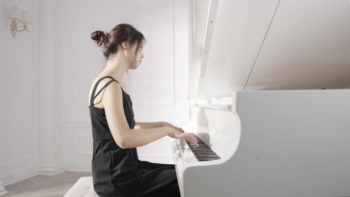 年轻女人在白色房间弹钢琴