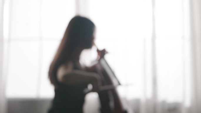 女人在房间演奏大提琴