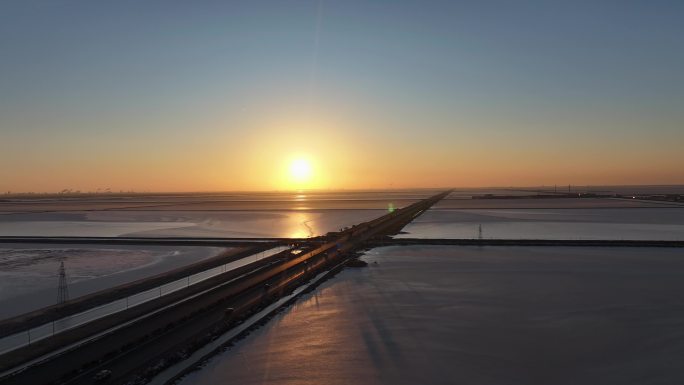 冬季夕阳晚霞照射公路及两侧水面冰面人文美景唯美