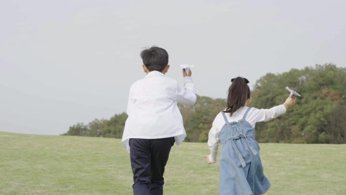 男孩女孩在草地奔跑背影