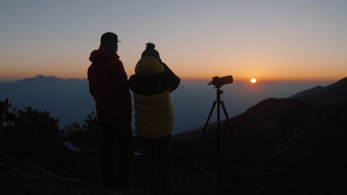 N男女在山顶拍日出夕阳