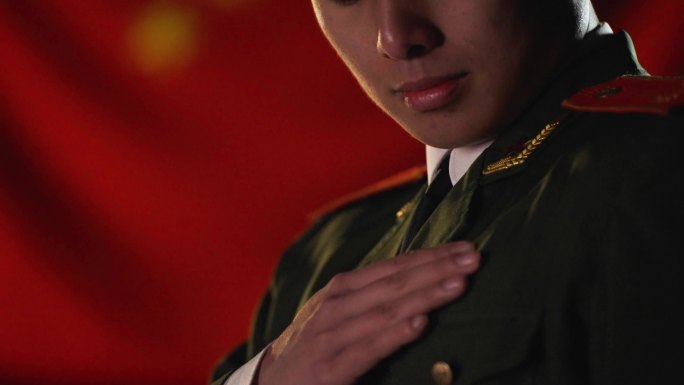 军人面对国旗抚摸军装