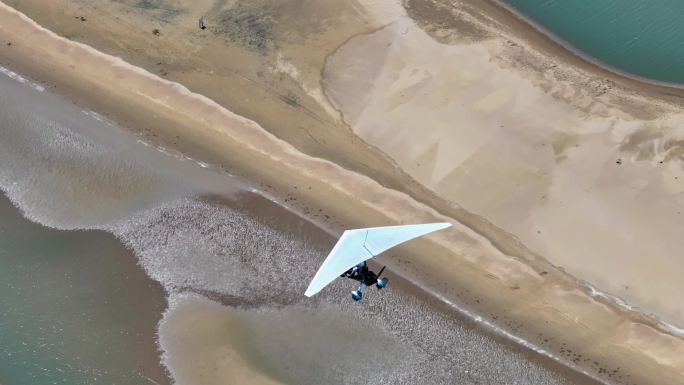 航拍滑翔机载游客海岛上空飞翔