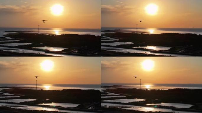 航拍夕阳晚霞照射海面水面滑翔机小岛上空飞翔