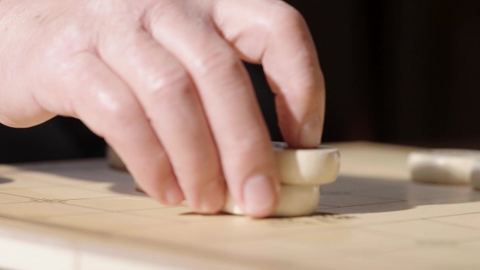 手拿象棋棋子棋盘特写