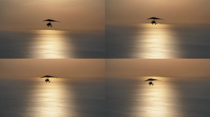 滑翔机在夕阳照射的水面上飞翔