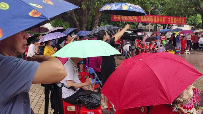 公益表演公园广场社区老人演出观众雨中围观