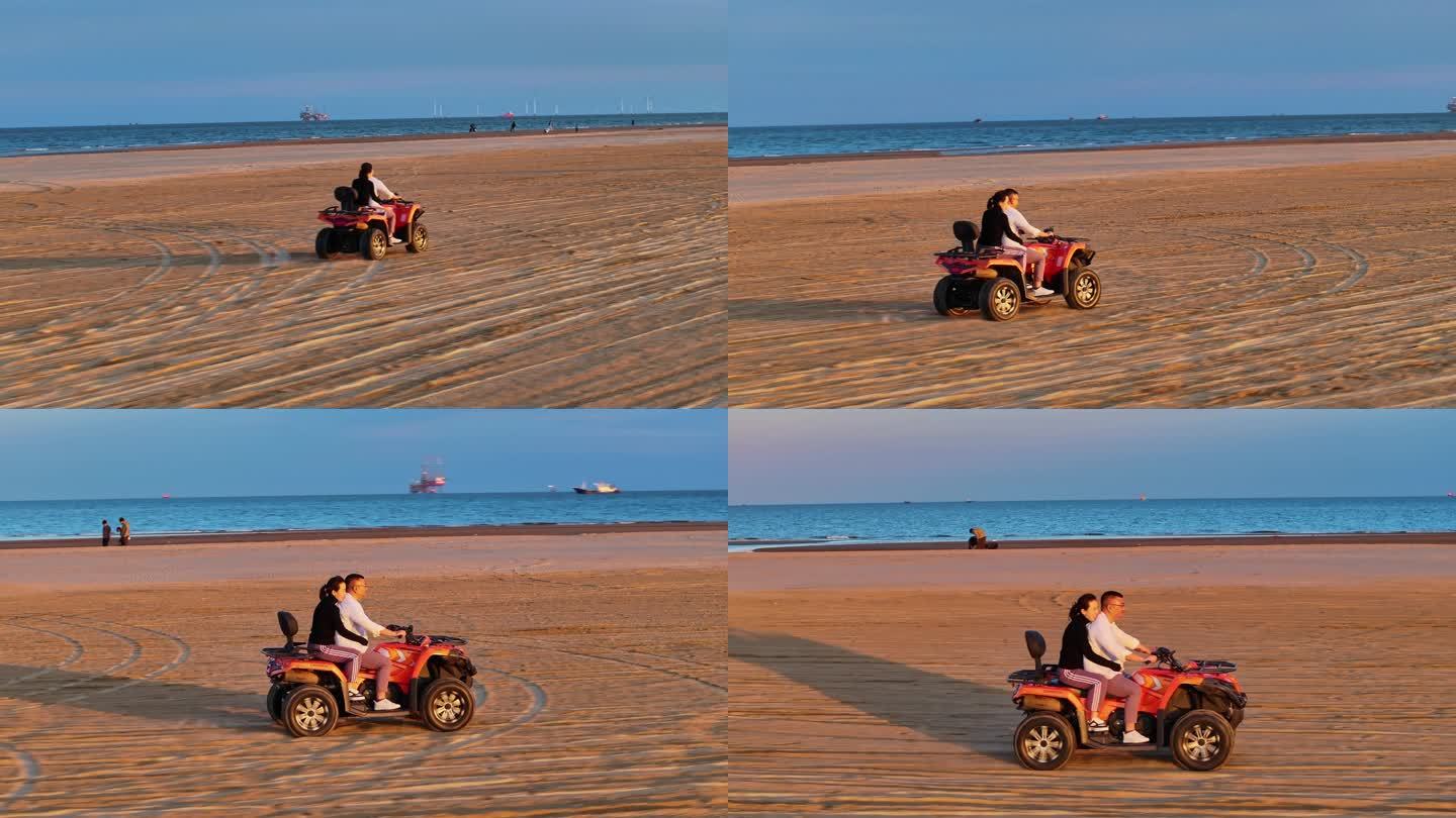 航拍4K夕阳晚霞中游客情侣在海边沙滩骑沙滩摩托