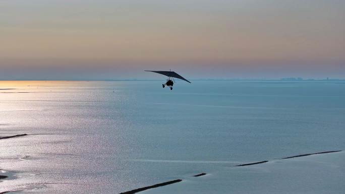 航拍滑翔机载客在月岛海岛上空飞翔剪影