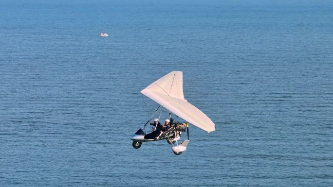 三角滑翔机载乘客飞翔在月岛岛屿小岛上空