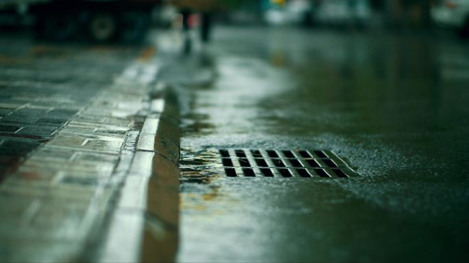 氛围感下雨街道下水道雨滴潮湿路面行人