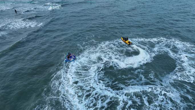 海边度假游客游玩水上项目摩托艇拖拽充气沙发