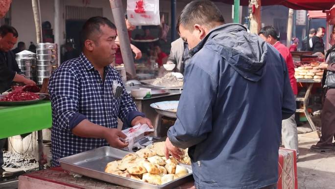 新疆巴扎上卖烤包子的商户和客人