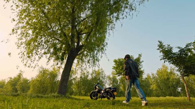 阳光下一个青年和复古摩托车