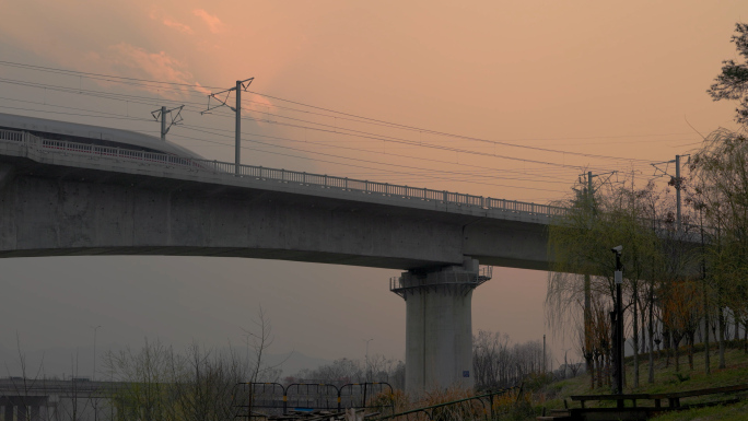 黄昏 夕阳下的和谐号动车列车缓慢驶过桥梁